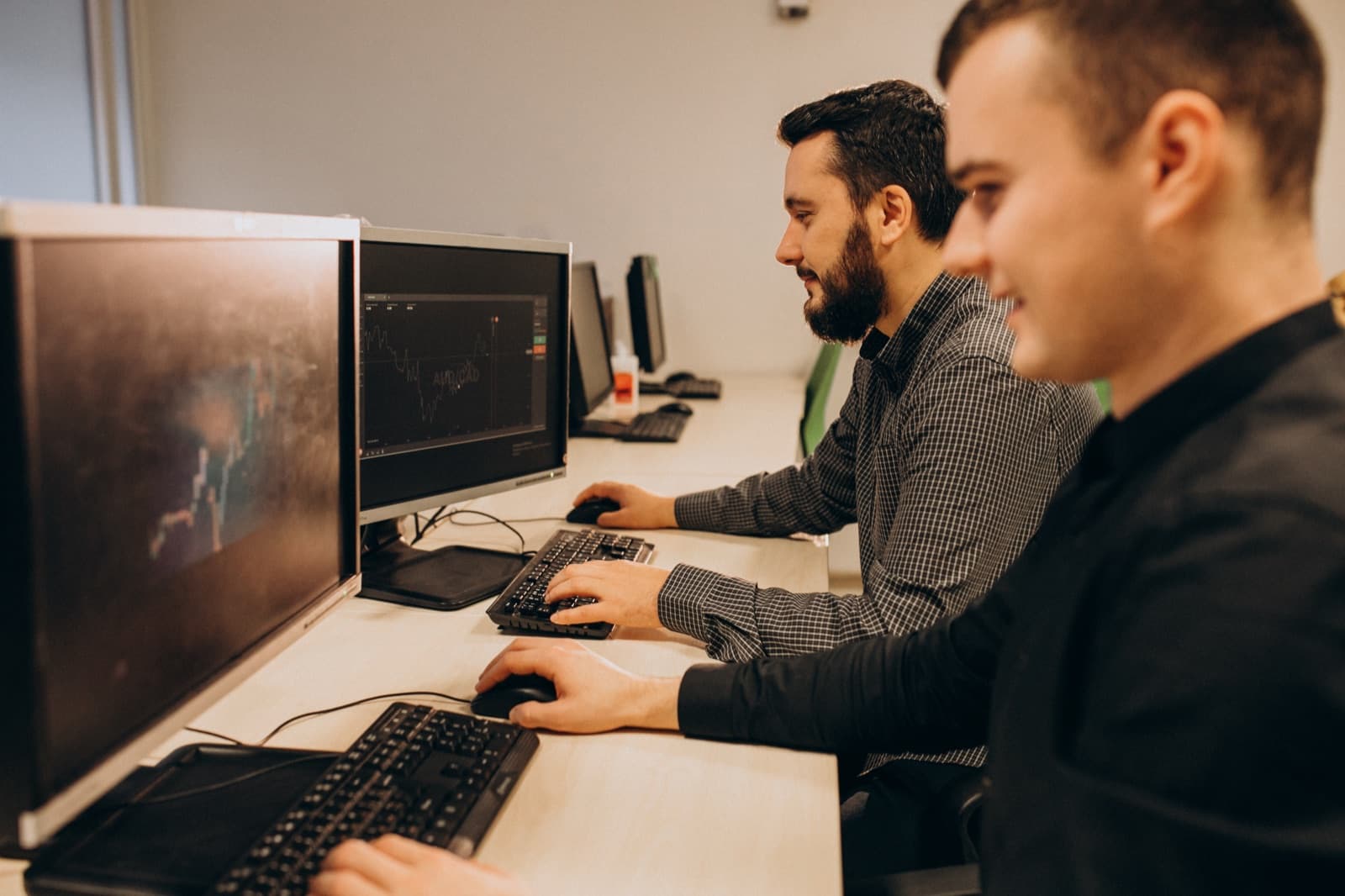 Two engineers working side by side at desktop monitors
